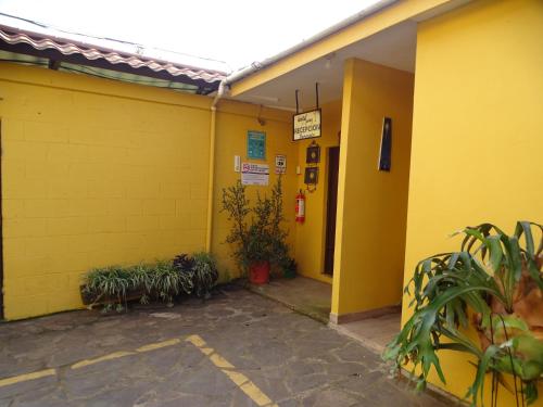 康塞普西翁德阿塔科Hostal Juarez Ataco的黄色的建筑,有一排盆栽植物