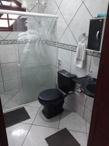 坎普斯戈伊塔卡济斯Guarus house plaza shopping的浴室设有黑色的卫生间和水槽。