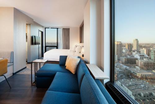卡尔加里Residence Inn by Marriott Calgary Downtown/Beltline District的酒店客房配有蓝色的沙发和床。