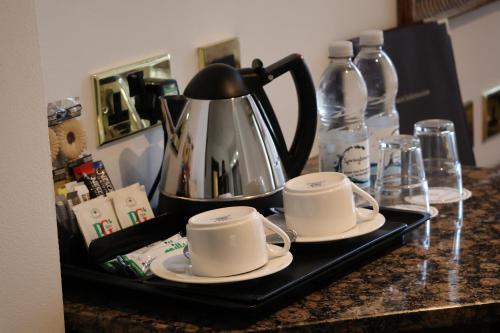 伦敦伦敦肯辛顿德瑞姆泰尔酒店的盘子上放有2杯茶壶和茶壶