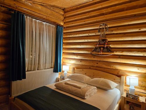 坎普朗莫道尼斯Cabana Alesia, relaxare la poalele Raraului的一间卧室设有木墙和床