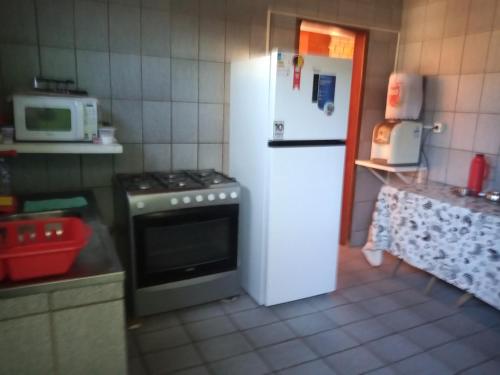 嘎林海斯港Casa de Porto de Galinhas 137的厨房配有炉灶和白色冰箱。