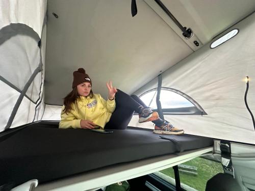 里瓦德塞利亚Live On The Horizon 2的坐在帐篷里的床上的女孩