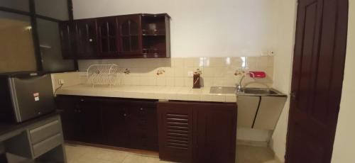 康提Reverie Hill Bungalow, Kandy的厨房配有棕色橱柜和白色台面