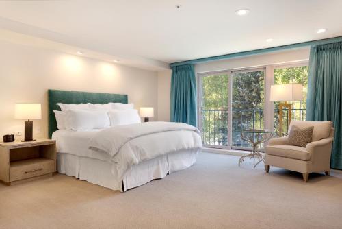 范尔盖拉特恩山林小屋的一间卧室设有一张大床、一把椅子和窗户。