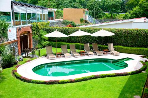 迪坡斯特兰Nuevo Amanecer的庭院内带椅子和遮阳伞的游泳池