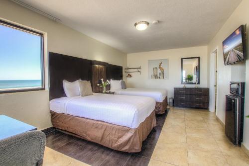 代托纳海滩La Bella Oceanfront Inn - Daytona的酒店客房设有两张床和大窗户。