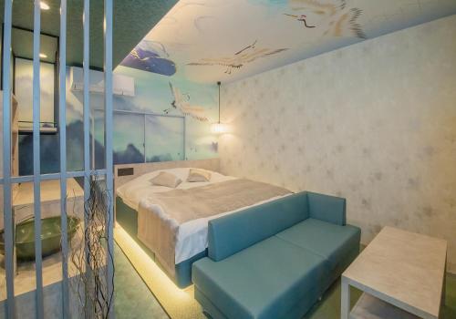姬路Hotel Kaguya的一间卧室配有一张床和一张蓝色的沙发