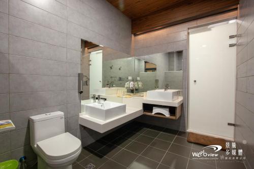 玉里镇拾光悠宿的浴室设有2个水槽、卫生间和镜子。