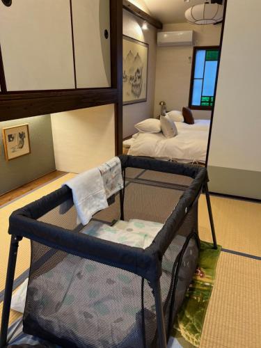 京都Imakumano Terrace - Mokubei An 木米庵的一间设有镜子和一张带床的婴儿床的房间
