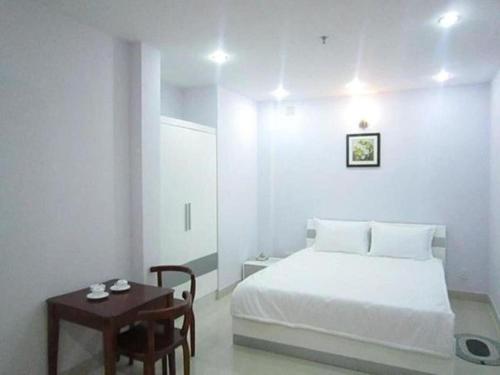 胡志明市Lê Đại Phát Hotel - 498 An Dương Vương ,Q6 - by Bay Luxury的白色卧室配有床和桌子
