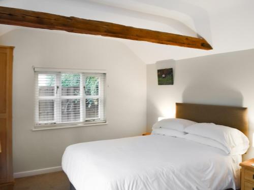 萨德伯里The Six Bells Barn的卧室配有白色的床和窗户。