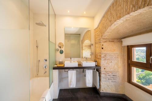 塞哥维亚Áurea Convento Capuchinos by Eurostars Hotel Company的一间带两个盥洗盆和淋浴的浴室