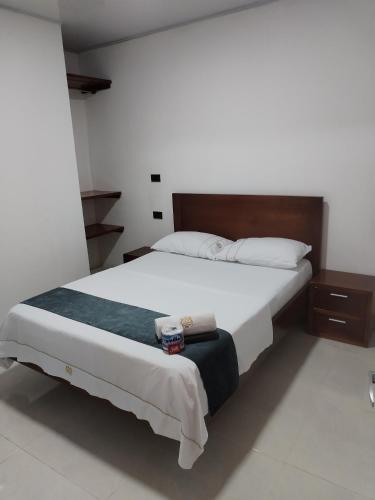 SaravenaHotel Ariza Real的一间卧室配有一张带白色床单的大床