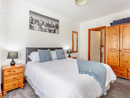 Chew Magna2 bed property in Bath 37147的卧室配有白色的床和木制橱柜。