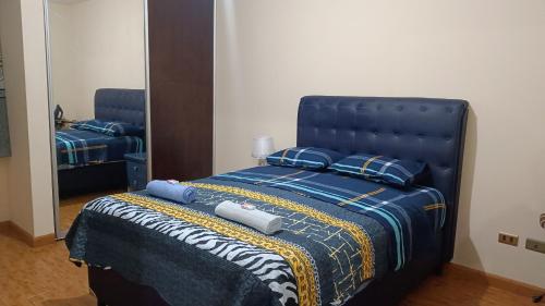 科恰班巴Elegante y Céntrico depto próximo al Prado的一间卧室配有一张带镜子的蓝色床