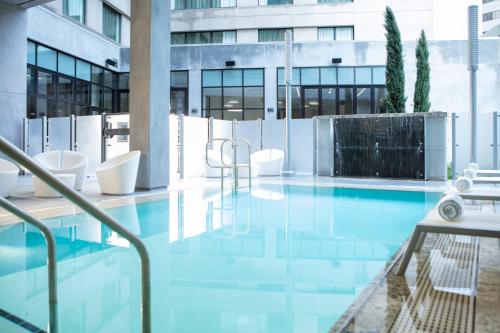 圣何塞圣荷西市中心万豪酒店的一座带白色椅子的建筑中的游泳池
