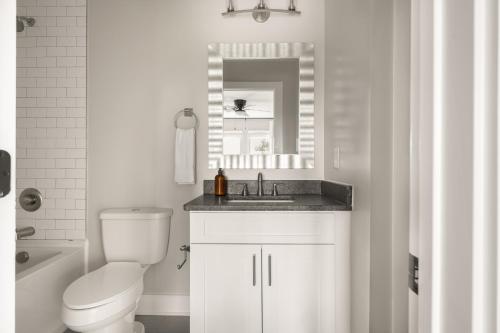 纳什维尔McCreery by AvantStay Stylish Spacious Nashville Flat w Modern Design的一间带水槽、卫生间和镜子的浴室