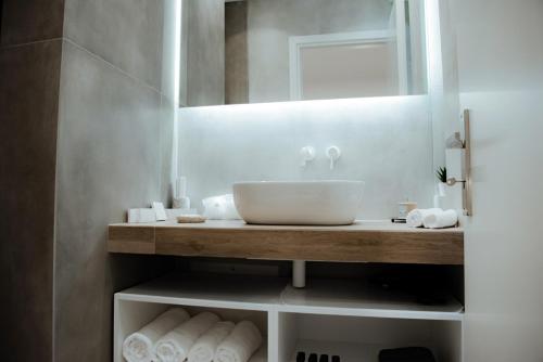 雅典Athens Muses Suites的浴室配有盥洗盆、镜子和毛巾