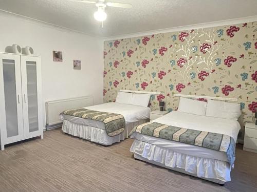 大雅茅斯The Dolphin Hotel的花卉壁纸客房内的两张床