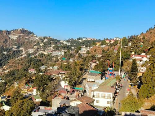 穆索里The Mussoorie home stay的山丘上的小镇,有房子和树木