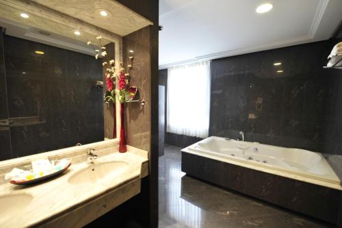 安特克拉罗桑洛酒店的一间带浴缸和大镜子的浴室