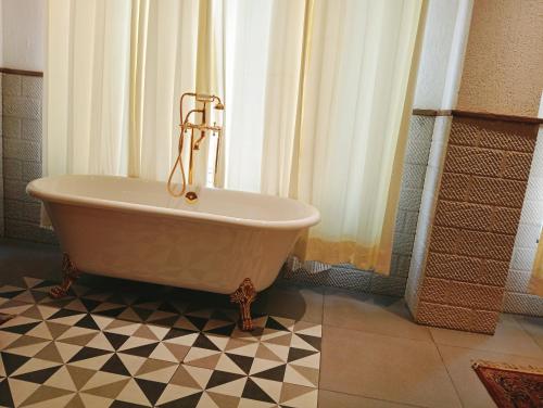 MohaliHOTEL CENTRA的浴室设有浴缸,位于瓷砖地板上