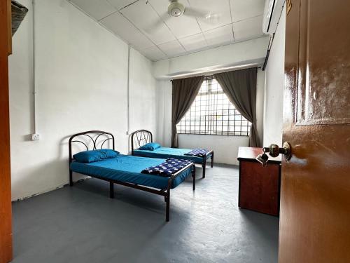 乌鲁地南Jiaxin Dormitory - Puteri Wangsa 家馨旅舍的两张床铺位于带门的房间