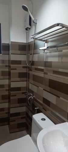 BoronganLorraine Suites的浴室配有卫生间、淋浴和盥洗盆。