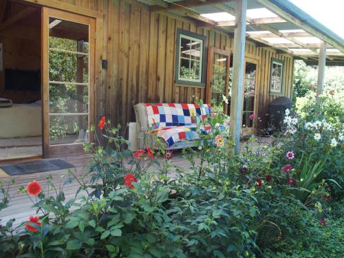 Parapara Woodland eco retreat的一个带沙发和鲜花的房子的门廊