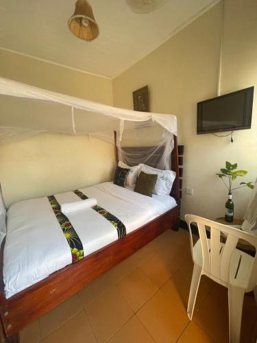 KihihiSuba Motel的一间卧室配有一张带天蓬的床