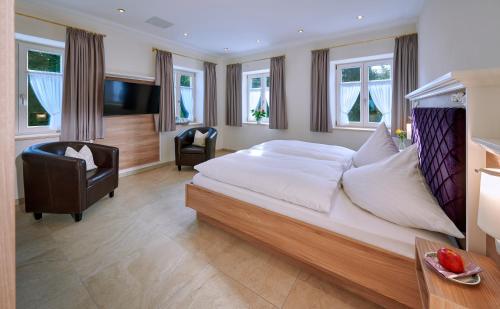 基姆湖畔贝尔瑙Ferienwohnungen im Bonnschloessl的一间大卧室,配有一张大床和一把椅子