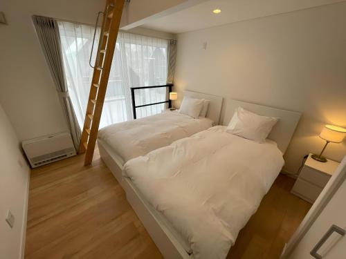 Rankoshi【ペット可】Niseko STREAM Villas的小型客房的两张床,设有梯子