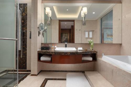 滨海新区天津滨海皇冠假日酒店的一间带水槽、浴缸和淋浴的浴室