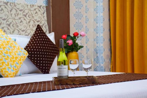 马拉里Hotel Hadimba Manali By YB Hotels的一张桌子,上面放有两瓶葡萄酒和两杯酒