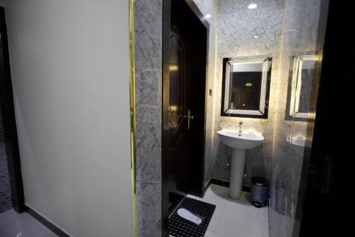 利雅德علم الفريدة للوحدات السكنية المفروشة Alam Faridah Hotel的一间带水槽和镜子的浴室