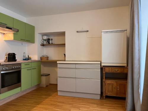 巴德米滕多夫澳贝尔思多尔费勒霍夫酒店的厨房配有绿色橱柜和白色冰箱
