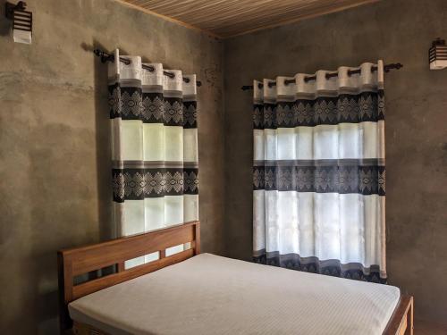 米欣特莱Afenta Hotel - Mihintale的一间卧室配有床和带窗帘的窗户