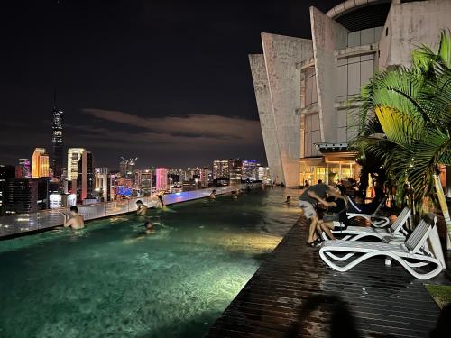 吉隆坡Regalia Spritz Empire Hostel的一座晚上拥有城市天际线的游泳池