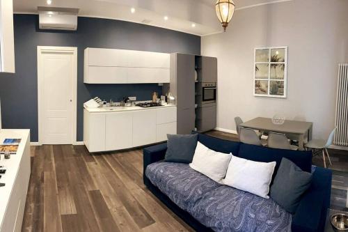 阿拉西奥Nuovo Appartamento Borgo Coscia的一间带蓝色沙发的客厅和一间厨房
