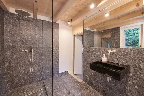 UrfeldUrfeld26 Walchensee Berghaus mit Sauna的一间带玻璃淋浴间和水槽的浴室