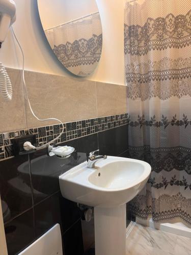 那不勒斯Oceania Hotels Napoli的一间带水槽和镜子的浴室