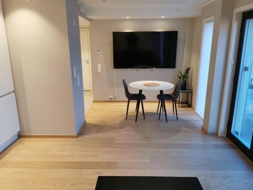 斯沃尔韦尔Svolvær city center apartment的客厅配有桌椅和电视。