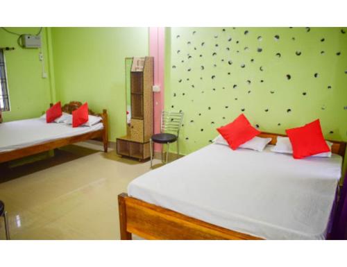 Hotel Poba, Jonai, Assam的一间卧室配有两张带红色枕头的床