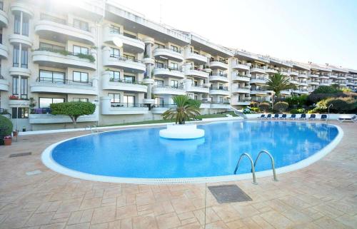 圣维森德马尔Estupendo apartamento en San Vicente do Mar O Grove的大楼前的大型游泳池
