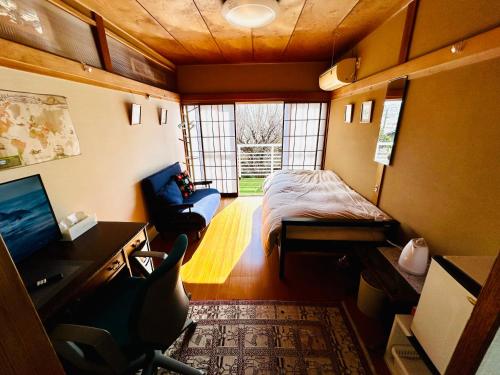 京都Sakura house的小房间设有一张床、一张桌子和一把椅子