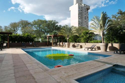 伊瓜苏维达黄金套房酒店的一座游泳池,其建筑背景为: