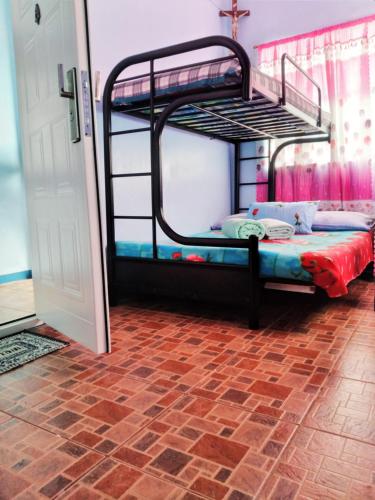 碧瑶ARSIAM Transient Room的砖地板客房中的两张双层床