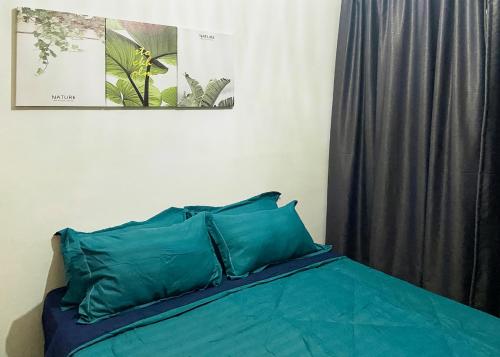 雪邦AM LUXURY HOMESTAY @ KLIA 1 KLIA 2的卧室内的一张带蓝色枕头的床