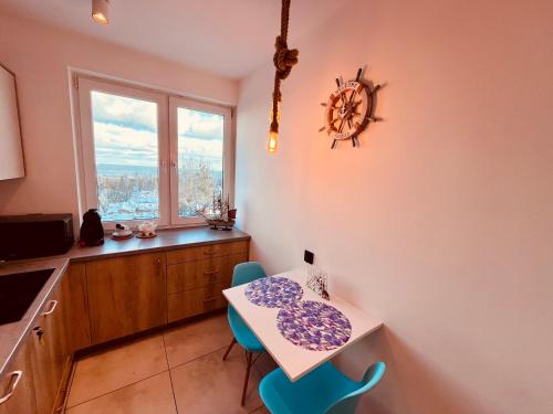 索波特Apartament Karlikowska z widokiem na morze的厨房配有桌椅和窗户。